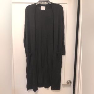 Long, black, lightweight cardigan with slights on the sides and pockets.
